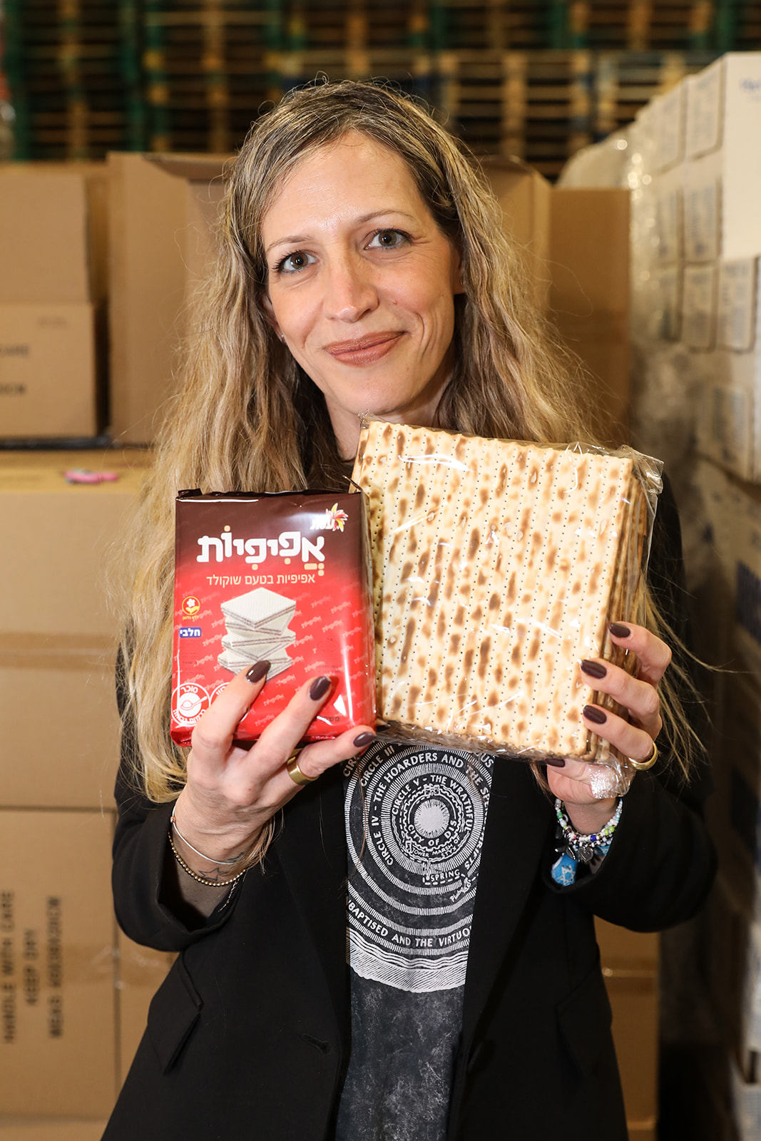 עובדת שטראוס מחזיקה מצות ואפיפיות ומחייכת למצלמה